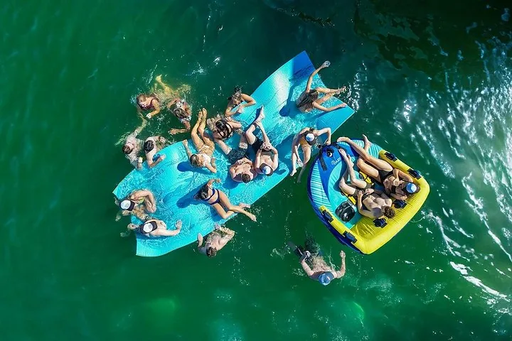 Aerial view of people on floating mats and tubes in the ocean